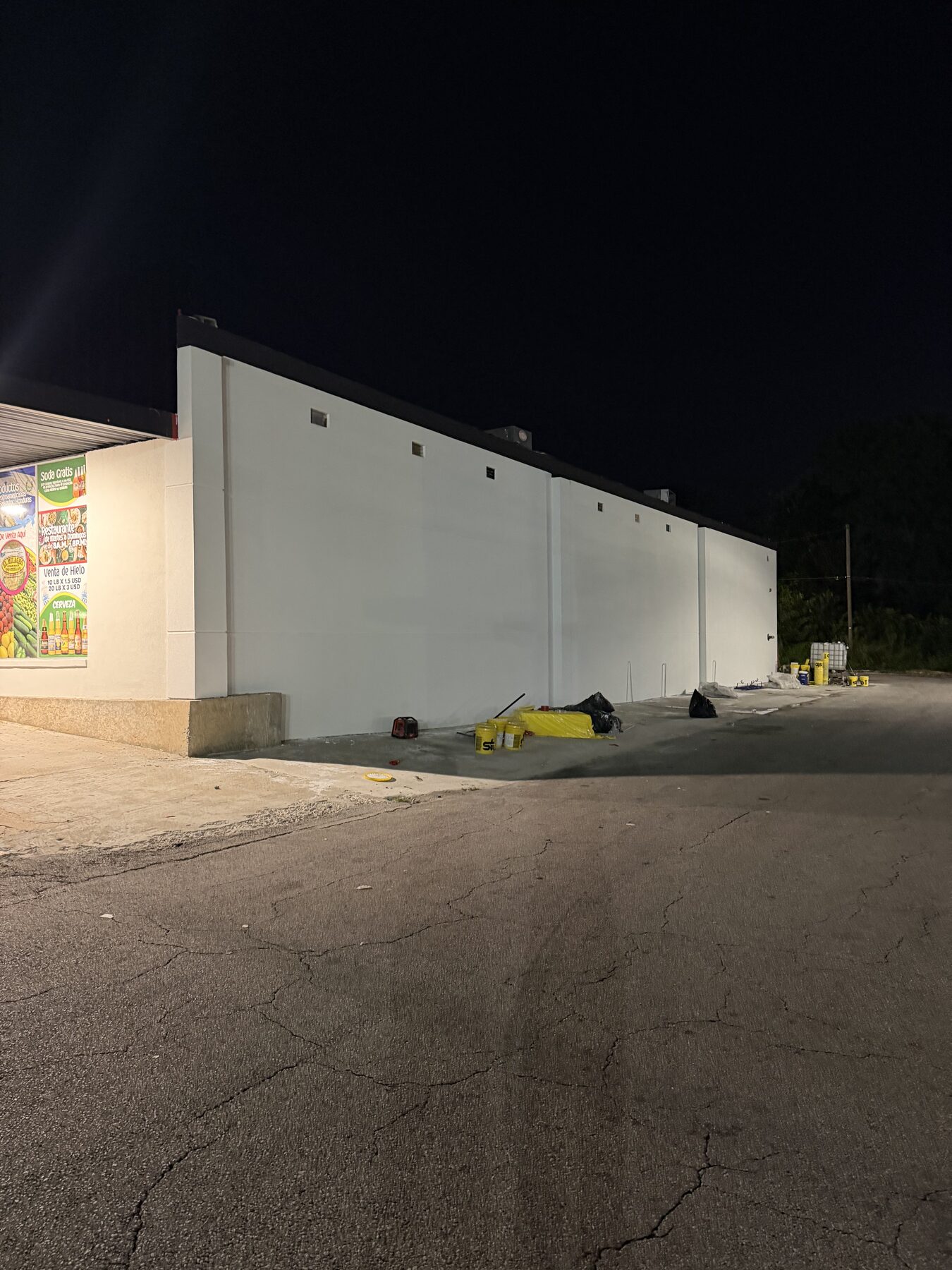 La Guadalupana market with a fresh white stucco side wall at night