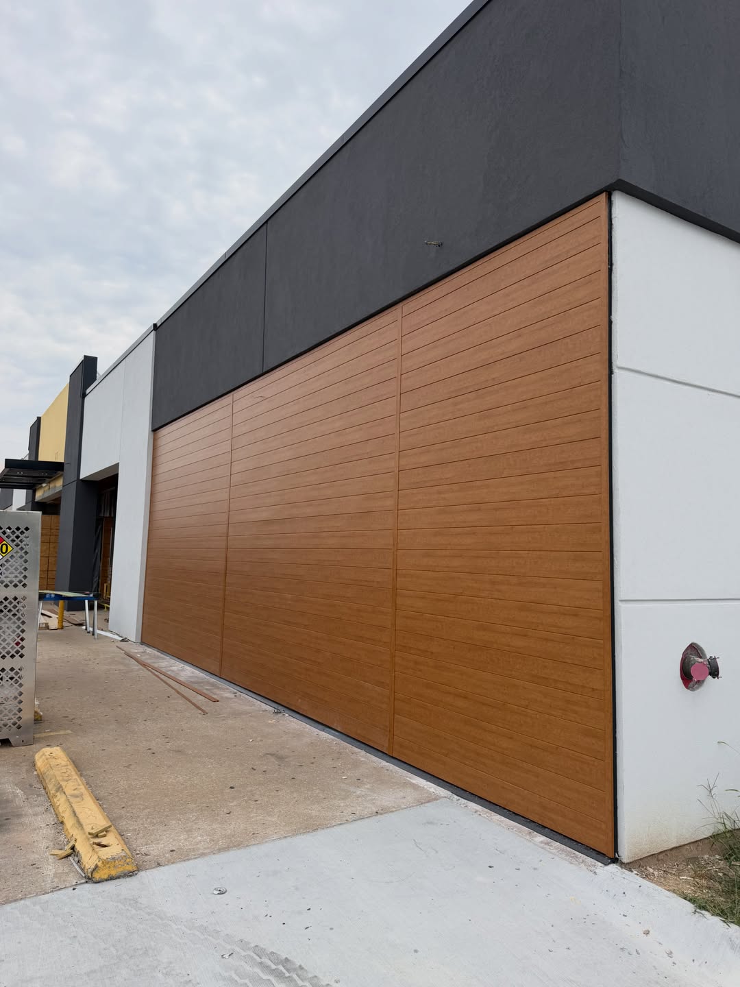 Modern commercial building with warm wood-look and dark stucco panels