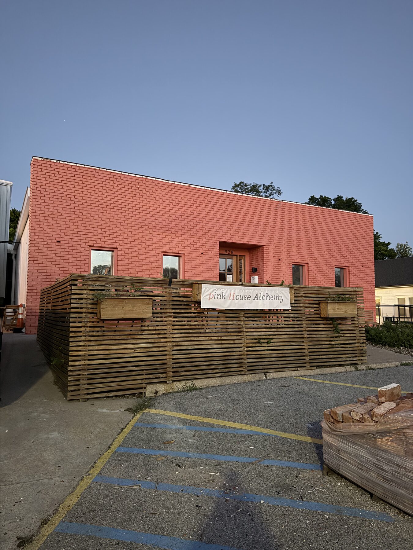 Pink House Alchemy building with freshly painted coral masonry exterior at dusk